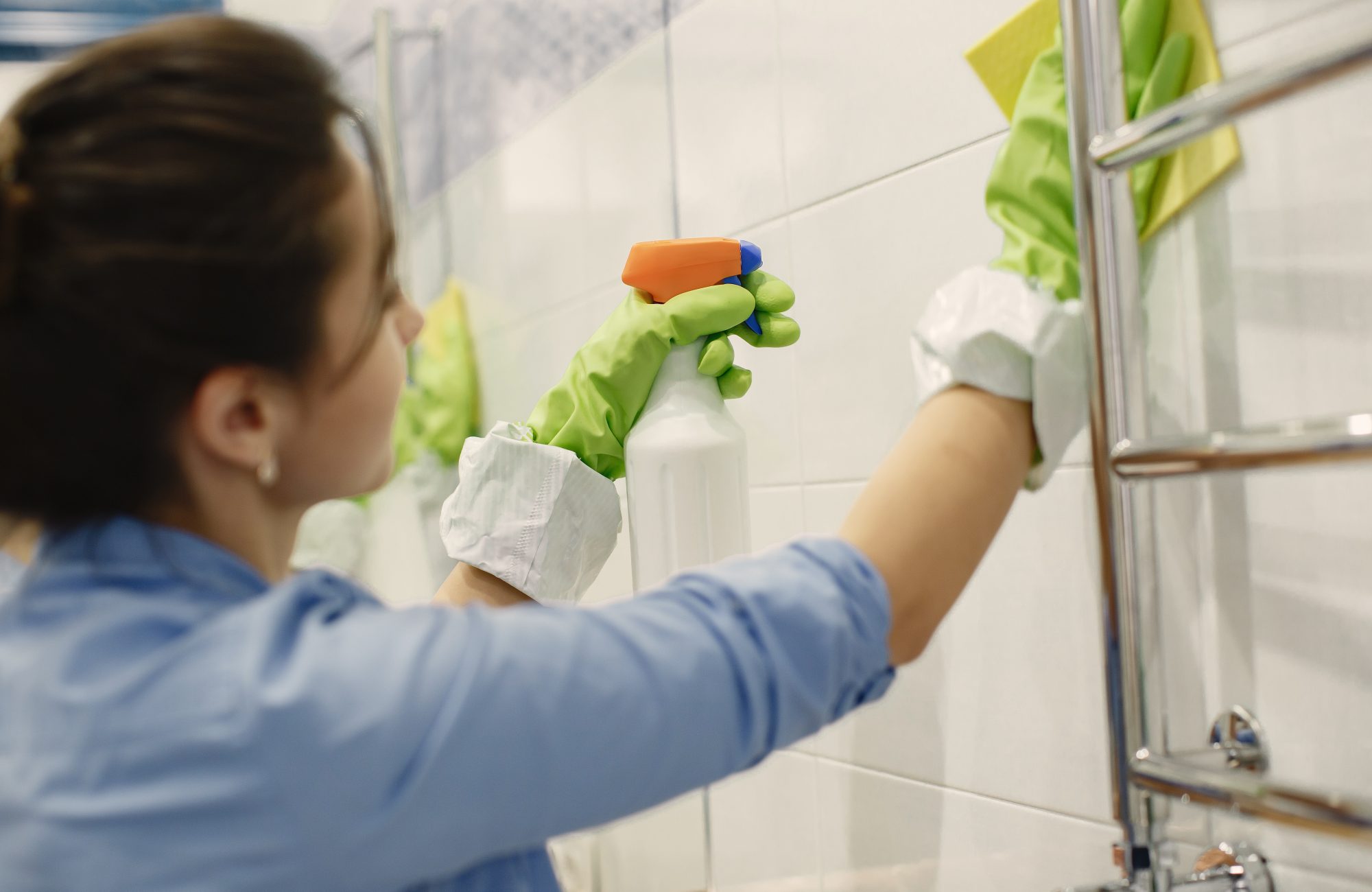 Woman with sponge and rubber gloves cleaning house